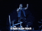 a large crowd of people at a concert with their hands in the air .
