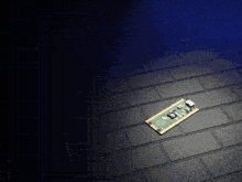 a small electronic device is laying on a black tiled floor