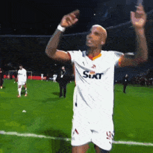 a soccer player wearing a sixt shirt is celebrating on the field