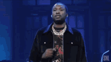 a man singing into a microphone with snl written on the bottom