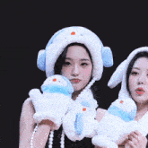 a woman wearing a hat and scarf holds a stuffed animal with the word muze on the bottom