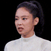 a close up of a woman 's face with a ponytail .