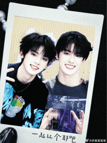 a polaroid picture of two young men with chinese writing on the bottom