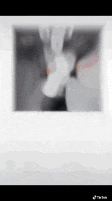 a blurred image of a person 's hand holding a white object .