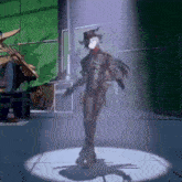 a man in a cowboy hat is standing in a room with a spotlight on him .