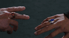 a man 's hand is reaching out towards a woman 's hand with a ring on it