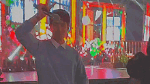 a man in a grey sweater is holding a hammer in front of a colorful background