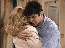 a man is hugging a woman in a room