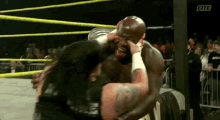 a man is wrestling another man in a ring .