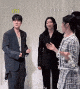a man in a suit and a woman in a plaid jacket are standing next to each other with a question mark above them