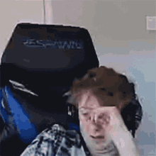 a man is sitting in a black and blue gaming chair .
