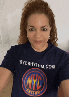 a woman wearing a nyc rhythm shirt takes a selfie