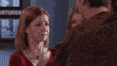 a man and a woman are hugging each other and the woman is kissing the man on the cheek
