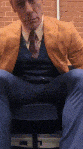 a man in a suit and tie is sitting in a chair