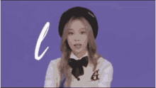 a girl wearing a beret and a bow tie is standing in front of a purple background that says las n