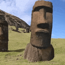 a statue of a man with a beard is standing in the grass