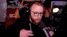 a man wearing glasses and headphones is talking into a microphone with the words tiger writer behind him