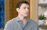 a close up of a man wearing a blue polo shirt .