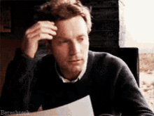 a man holds his hand to his forehead while holding a piece of paper with the word bereshtook on the bottom