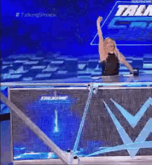 a woman is standing on a stage with her hand in the air .
