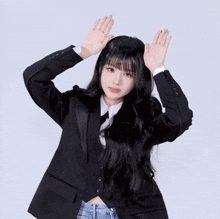 a woman in a tuxedo and tie is dancing with her hands in the air