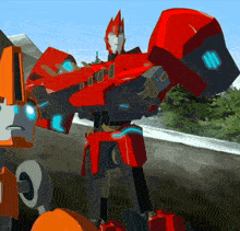 a red robot with a blue light on it 's chest is standing next to another robot .