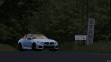 a blue bmw is parked in front of a sign that says start