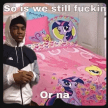 a man in a hooded jacket is standing in front of a pink bed with a pony on it .