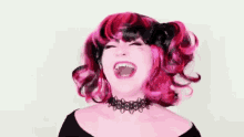 a woman in a pink wig and choker is laughing .
