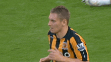 a man wearing a black and orange striped shirt that says karc on the front