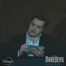 a man in a suit is holding a notepad and saying insane