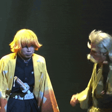 a man in a yellow kimono holds a sword in his right hand