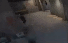 a blurry picture of two people running in a dark room .