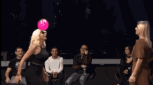 two women are dancing in front of a group of people who are sitting on chairs