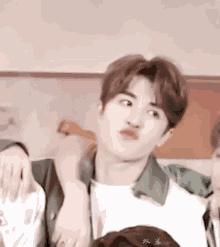 a close up of a person making a funny face with their hand on another person 's shoulder