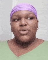 a woman wearing a green shirt and a purple headband