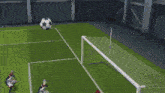 a soccer goalie is laying on the field while a player kicks the ball