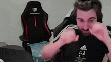 a man with a beard is sitting in front of a gaming chair .