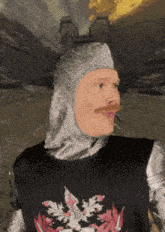 a man wearing a knight 's helmet and a black shirt