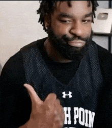 a man giving a thumbs up wearing a jersey that says h poin
