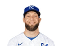 a baseball player with a beard wearing a blue hat and a white jersey .