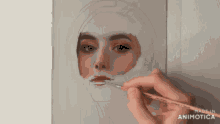 a person is painting a woman 's face on a canvas with a brush ..