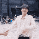 a man in a white shirt shakes someone 's hand in front of a sign that says ' korean ' on it