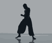 a silhouette of a man in black pants walking