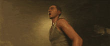 a man is standing in a dark room with a light shining on him