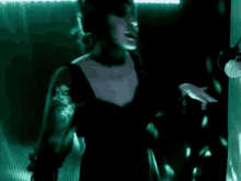 a woman in a black dress is standing in a dark room