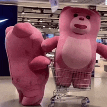 two pink teddy bears standing next to a shopping cart