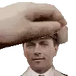 a man in a suit and tie is being touched by a hand .