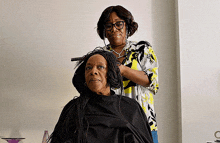 an older woman is getting her hair styled by a younger woman
