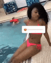 a woman in a pink bikini sits next to a pool